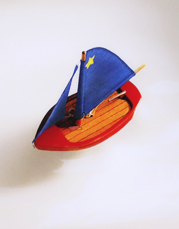 A toy sail boat sitting in a bath tub.